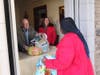 Mercy House staff members Steve Taylor and Annette Miller distribute food to a community member.