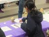 A visitor presses prayer cards to a relic, thereby transforming them into third-class relics suitable for personal prayer at home, during a sacred relics exhibit at Our Lady of Mount Carmel Oratory in Montclair on February 24, 2024.