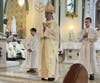 Dominic Auricchio and his younger brother, Maximo, assist Bishop Elias R. Lorenzo, auxiliary bishop of the Archdiocese of Newark, as altar servers during a Mass honoring fallen police officers at Our Lady of Fatima Parish in Elizabeth.