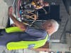 Market Manager Leo Keightley  checks his clip board for the count.  With Market Music Manager Bread Faucher playing searing guitar in back of him.. 