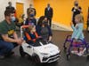 Emma, Go Baby Go car recipient, says hello to a fellow Go Baby Go family