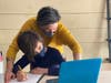 Parent working with child remote learning