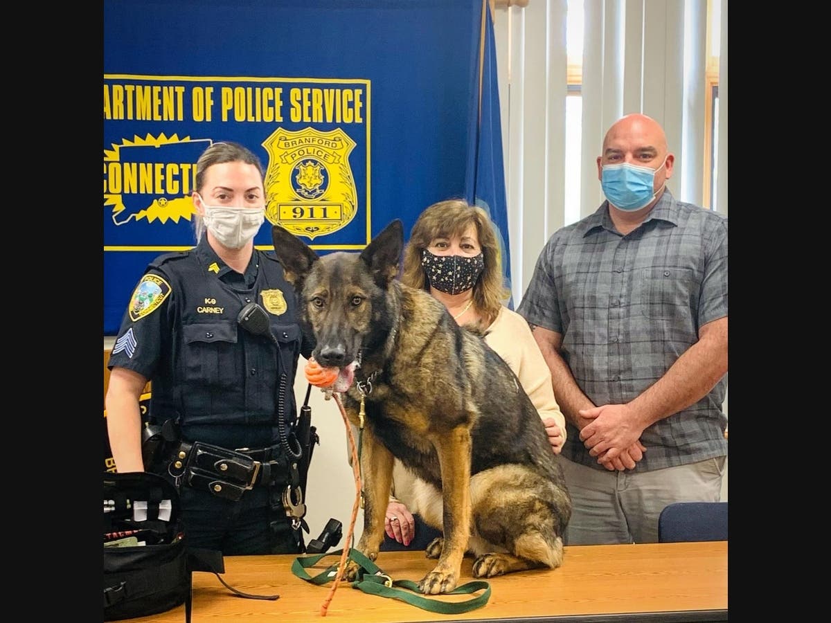 Branford Police Department K-9 Arrow poses with, from left to right: Sargent Melissa Carney, resident and donor Michele Hackley and Detective Art Farris. 