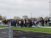 Students stand on the football field waiting for the rally to begin.