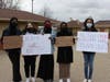 Students stand with their homemade signs after the rally.