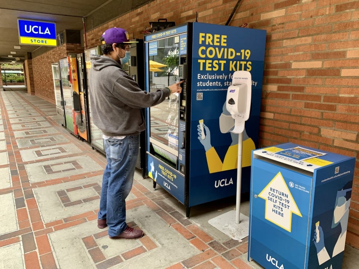 A man using a COVID-19 test vending machine on the UCLA campus.