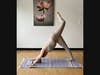 A woman does a yoga pose on an R-YOLO mat.