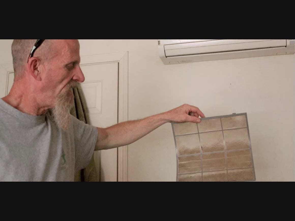 Zack Anderson, a Downtown Streets Team tenant living in South San Jose, holds up the filter from his air conditioning unit. He claims the air in his apartment is polluted with mildew. 