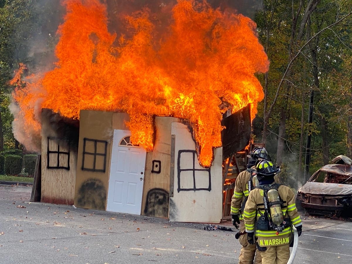 Golden's Bridge firefighters attack fire during dramatic demonstration of live-burn of a small house structure at the GBFD's annual Community Day event at the firehouse.