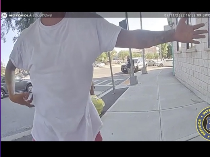 Rapper Styles P pantomimes holding a gun as he confronts police about arresting a woman stopped for riding an unregistered moped. 