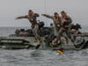 U.S. Marines and Sailors with Company A, 1st Battalion, 5th Marines, 1st Marine Division (1st MARDIV), and Company B, 3d Assault Amphibian Battalion, 1st MARDIV, jump off a P7/A1 assault amphibious vehicle (AAV).
