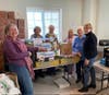 Members help organize and stock shelves of donated items.