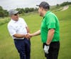 Sam L. Susser (left) greets a participant in the Susser Bank Golf Classic.