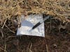 A fine, green mesh of plastic holds straw and grass seeds in place. Look closely at the top half of the white paper to see the "woven" squares of green plastic.