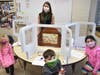 Seaford Harbor Elementary School social worker Sharon Klein works with students to create Kamishibai stories, which will be told using the small, wooden theater as a confidence boosting activity.  