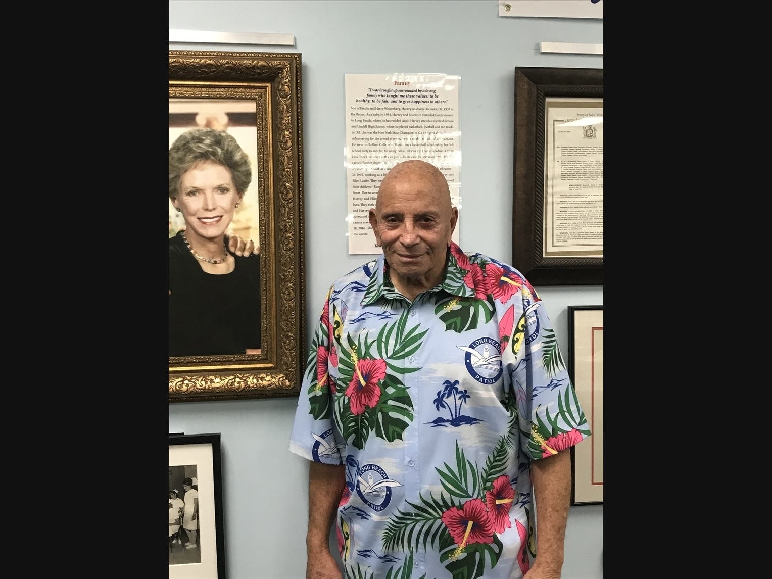 Former Assemblyman Harvey Weisenberg with his late wife Ellen framed behind him. 