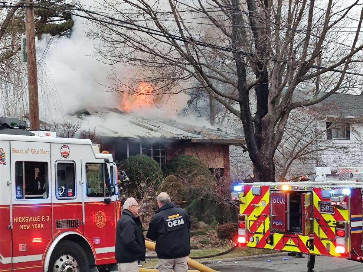 Flames shot out from a home in Hicksville on Wednesday afternoon. 