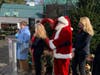 Greenwich Hospital President Diane Kelly speaks at the podium. Next to her is Mary Ann Grabavoy Heaven; Santa Claus, and Tiffany Benincasa of C. Parker Gallery.