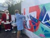 Greenwich Hospital President Diane Kelly signs the mural.
