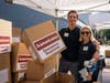 Ward and Alexa Horton assemble boxes to fill with hygiene kits at a volunteer event at Americares global headquarters in Stamford, Conn., on Wednesday, June 8, 2022.