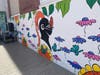 The mural features colorful flowers and leaves, insects and the SHS Black Knight logo right in the middle.