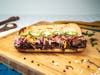 The shredded beef Latin Sub at Dicha: juicy shredded beef with a tangy slaw, cucumbers and thinly-sliced jalapeño peppers on warm bread.
