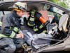 The Darien Fire Department’s 2nd Asst. Chief Alex Orsi examines the work of
firefighter Joe Bell operating the Holmatro spreader tools as they train on the new equipment.