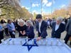 State Ren. Ryan Fazio (middle) lights a memorial candle outside of Greenwich Town Hall on Monday, Oct. 7, 2024.