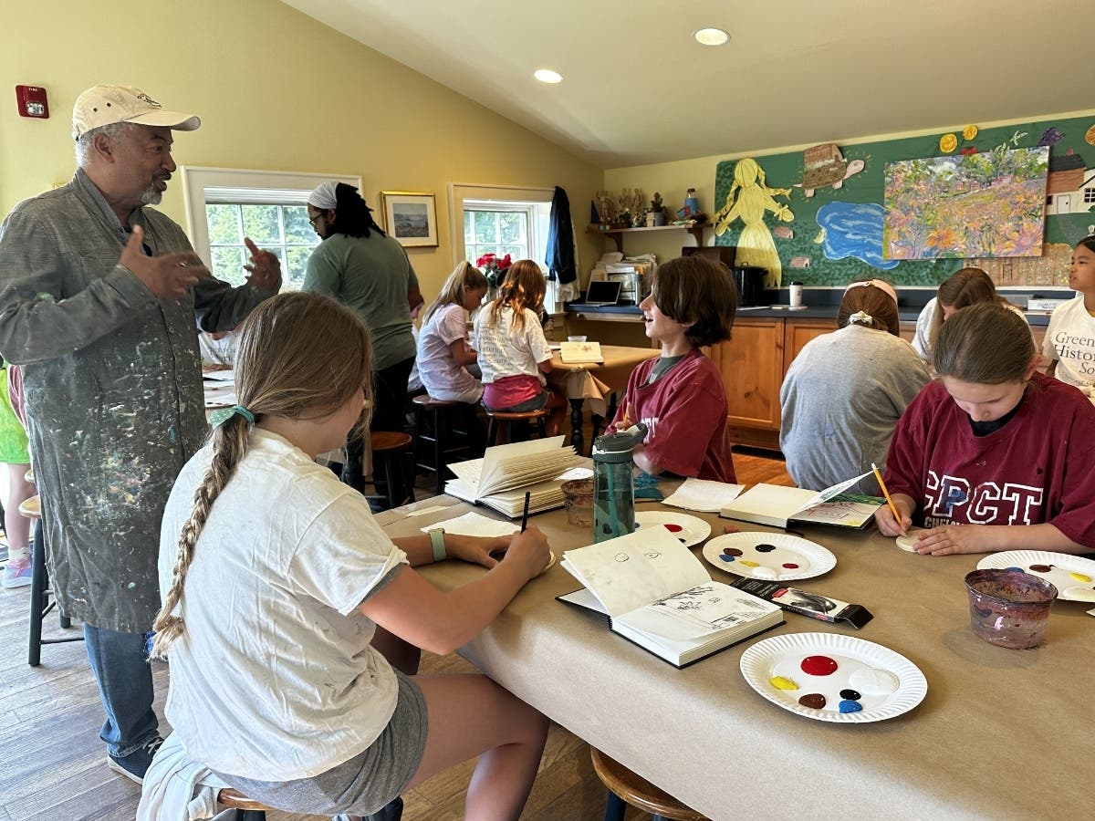 Painter and camp instructor Dmitri Wright (left) instructing campers.
