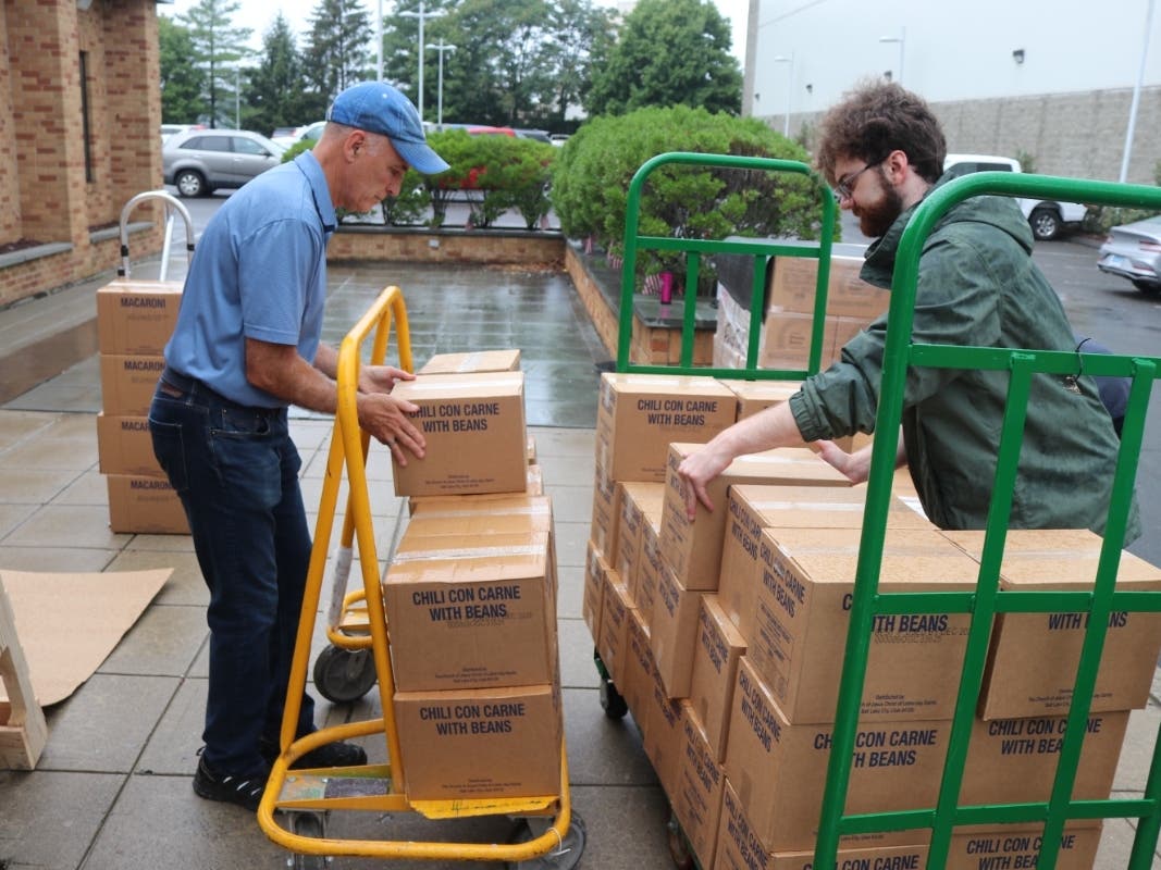 Mike Donoghue, Executive Director of Catholic Charities of Fairfield County, helps unload boxes with Garrett Winegar, Fairfield County resident and member of The Church of Jesus Christ of Latter-day Saints.