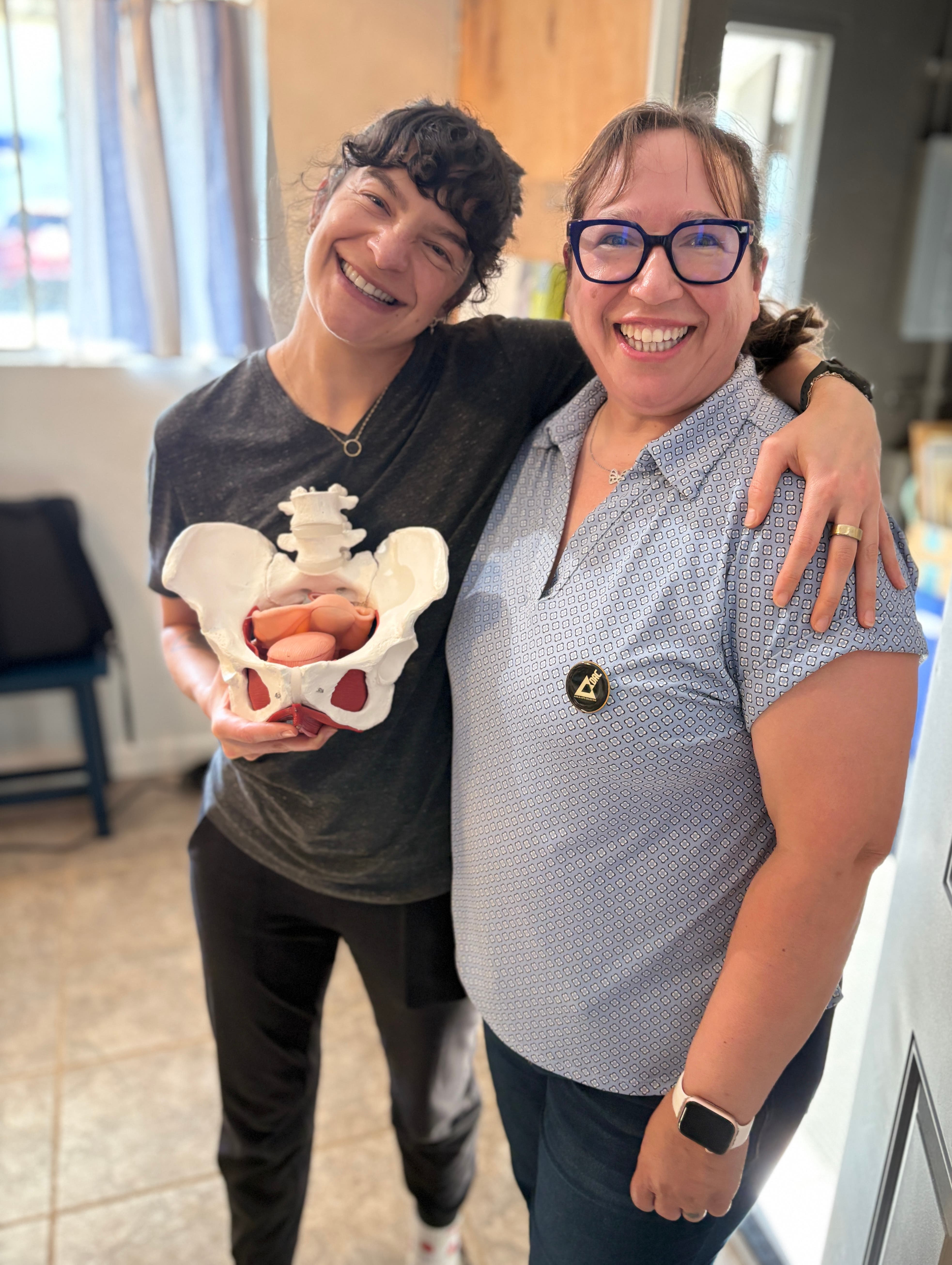 Two women and a pelvic floor anatomical model