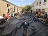 St. Charles company Aquascape donated the design and labor for phase one of the courtyard project. Here, VP of Field Research and Contractor Development Ed Beaulieu, students and volunteers lay a rubber liner for the ecosystem pond.