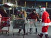 Santa and volunteers Olivia Morton, of Montgomery, and Bill Collins, of Naperville, fill a patron's car with gifts at the Wednesday distribution.