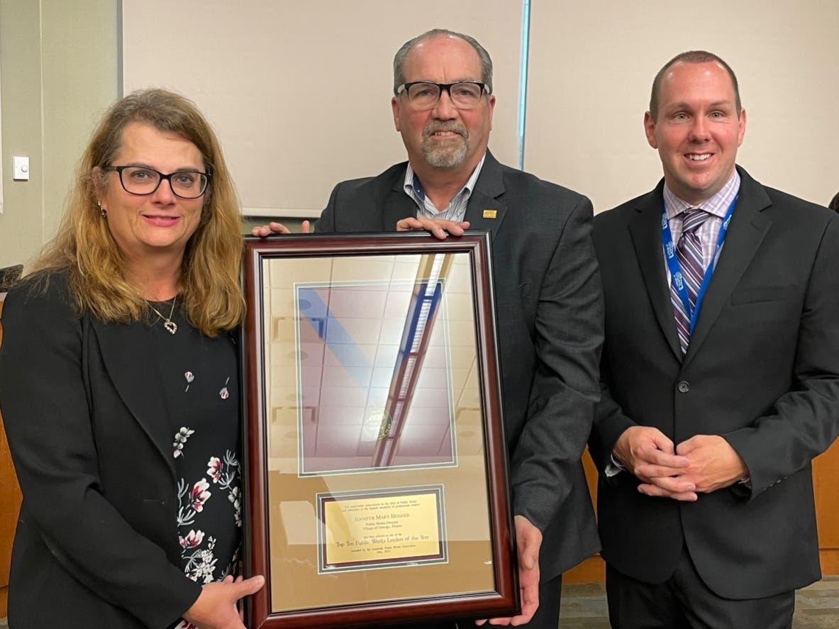 Oswego Public Works Director Jennifer Hughes, holding her award, is pictured with American Public Works Association’s past President David Lawry (center) and Village President Ryan Kauffman.