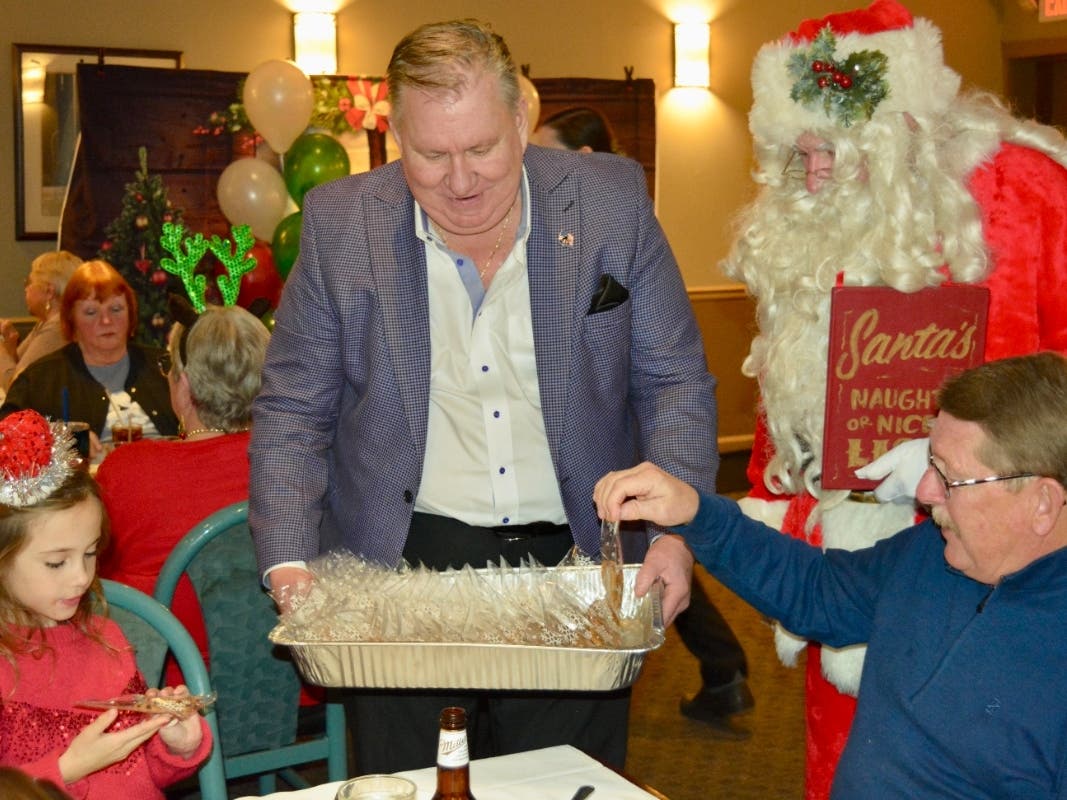 Orland Township Trustee John Lynch assists Santa Claus in passing out Christmas Cookies at Orland Township's Bingo with Santa