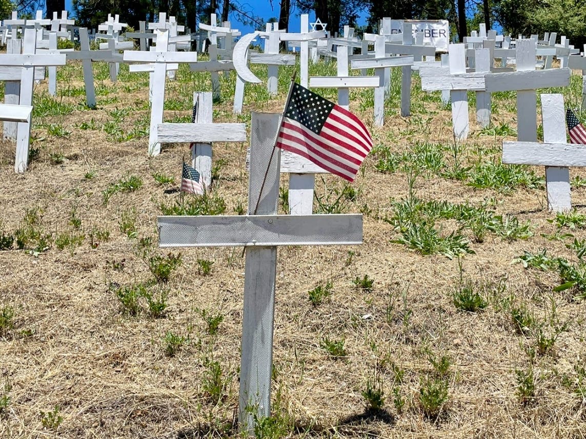 Photo of an America flag attached to a cross at the Lafayette Hillside Memorial, which will host a Memorial Day Vigil.
