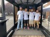 Owners Joseph Doheny, Eric Carlson, Matthew Modena, and Marc Ciarleglio standing inside of the mobile axe throwing trailer at their first event at Bad Sons Beer Co. 
