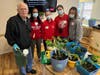Chelsea Place resident Alan Mitten joins Regis Jesuit High School students in Springtime planting.
