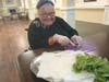 Mary Lee, Porter Place resident, preps basil for a recipe featuring freshly harvested vegetables from the sensory garden.