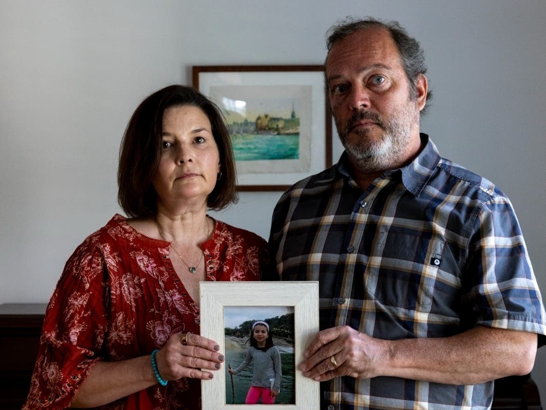 Alissa Johnson and Curt Johnson hold a photo of their daughter, Louisa or “Lulu,” in their Maplewood home on Sept. 4, 2026. Lulu died by suicide while experiencing a flare-up of a rare syndrome known as PANDAS in July 2021. 