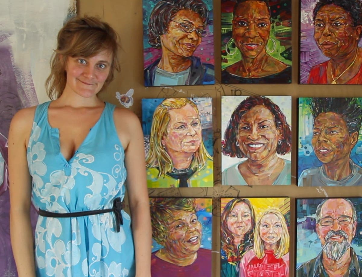 Gwenn Seemel stands in front of the 10 portraits she painted to accompany the book "The Future We Need." 