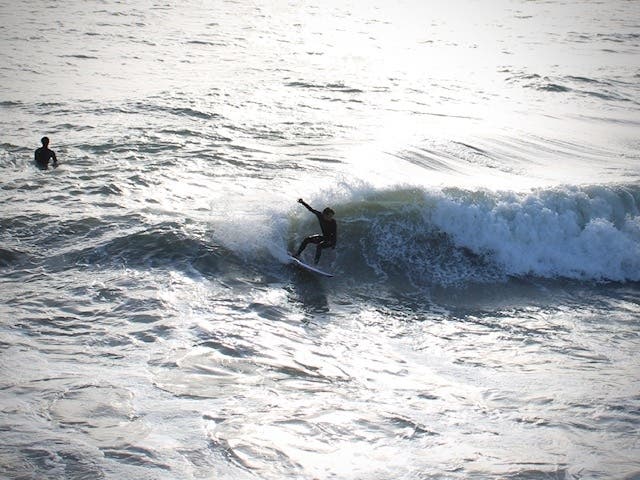 A surfer carves out a strong wave just north of the San Clemente Pier. 