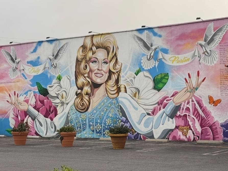To commemorate Dolly Parton's life and legacy, a candlelight vigil will take place in Costa Mesa at a massive mural located in town.