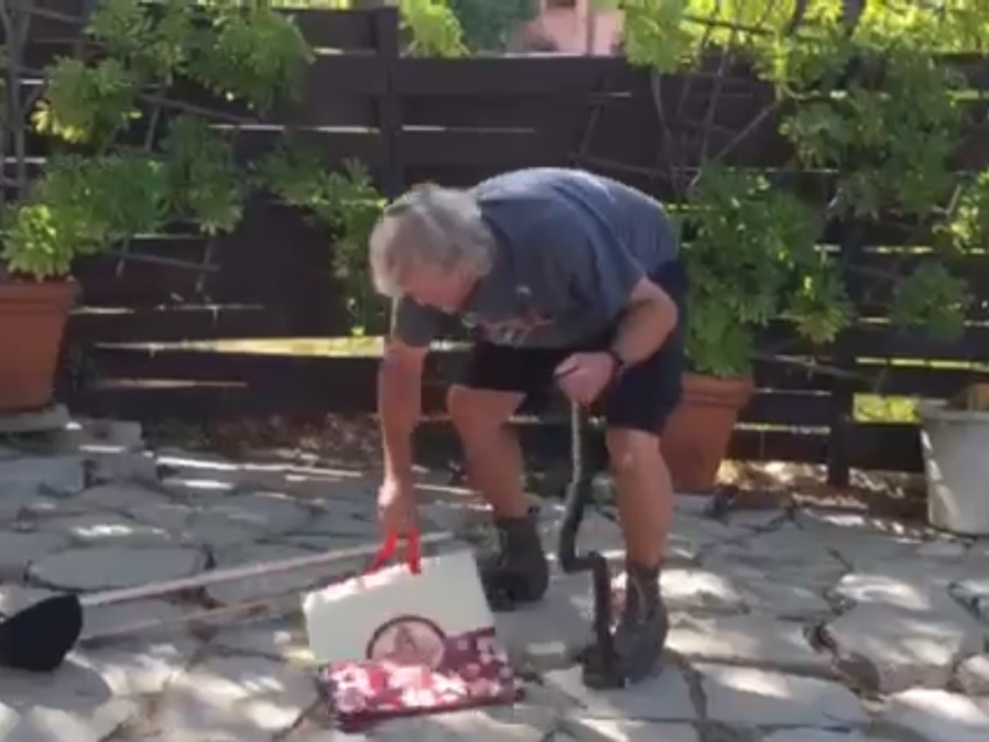 Dan Mac Neil catches a snake in someone's backyard. 