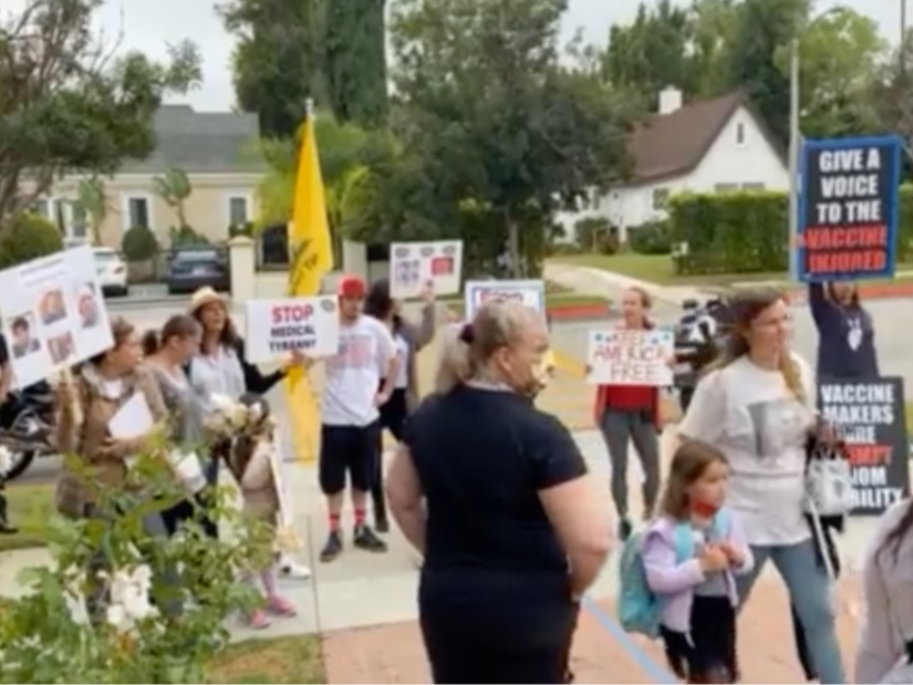 Protesters stand near Hawthorne Elementary School as parents walk their kids in. 