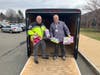 Rotarian Joe Muller helps Office Paul Dubiel load the trailer with toys donated by Rotary Club of Enfield members.