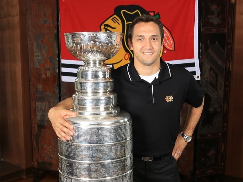 Nico Amoroso, head of IT for the Wirtz Corporation, stands with the Stanley Cup shortly after one of the Chicago Blackhawks' recent championship wins. 