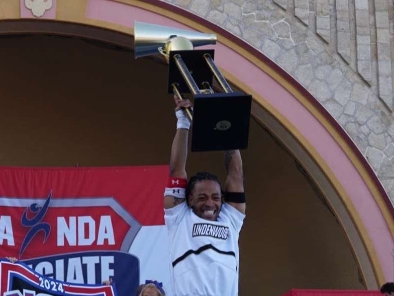 Phil Hill celebrates winning a fourth cheerleading national championship.