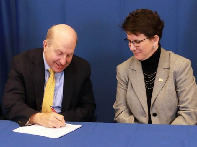 Pace President Marvin Krislov signs the agreement with Orange County Community College Dr. Kristine Young.
