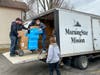 Subaru Ambassadors loading socks and toiletry kits into MorningStar Mission trucks for delivery